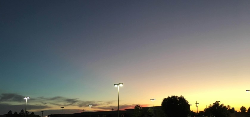 A sunset with many shades of blue, teal, red, and yellow.